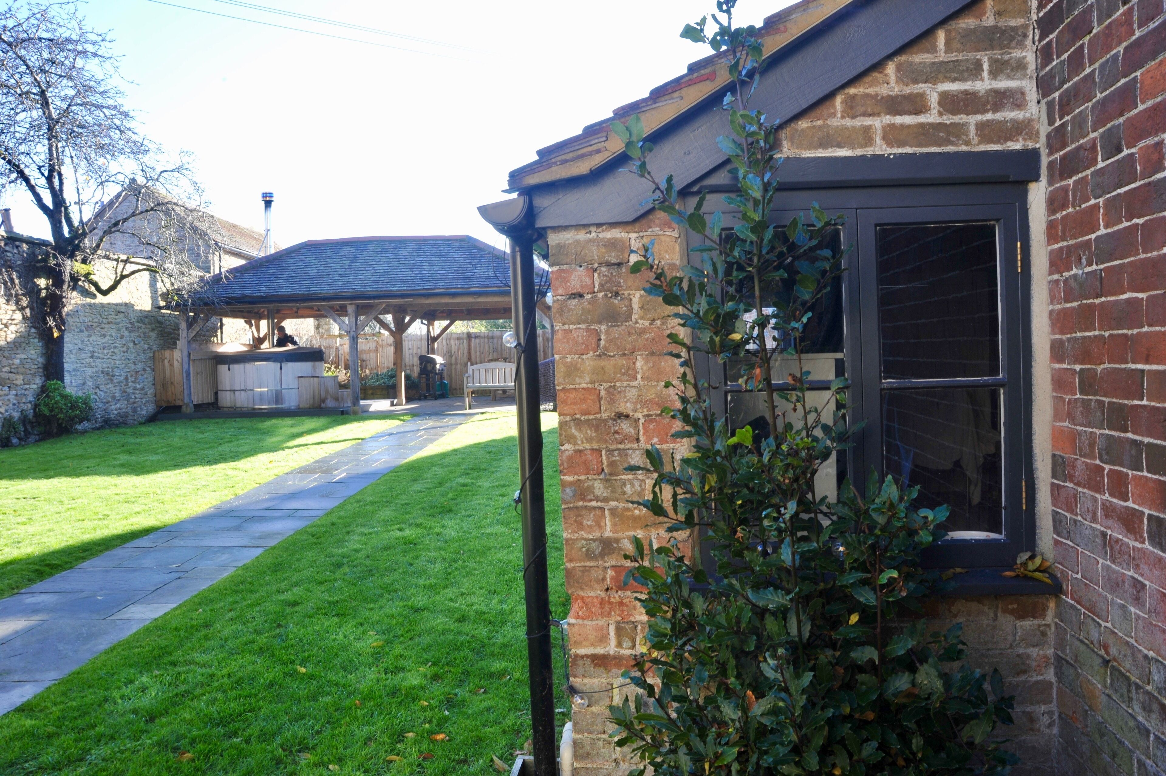 A brick house with a covered porch, a well-maintained lawn, and a clear sky.