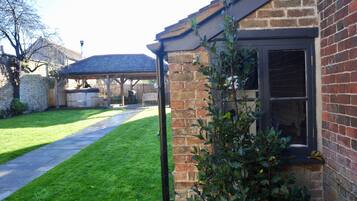 A brick house with a covered porch, a well-maintained lawn, and a clear sky.