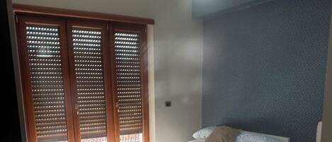 Escritorio, cortinas blackout y tabla de planchar con plancha
