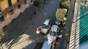 Une vue de rue avec des bâtiments, des voitures et un feu de circulation vert.