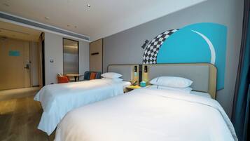 Ein Hotelzimmer mit zwei Betten, einem Schreibtisch, einem Sessel und einer großen Wandmalerei.