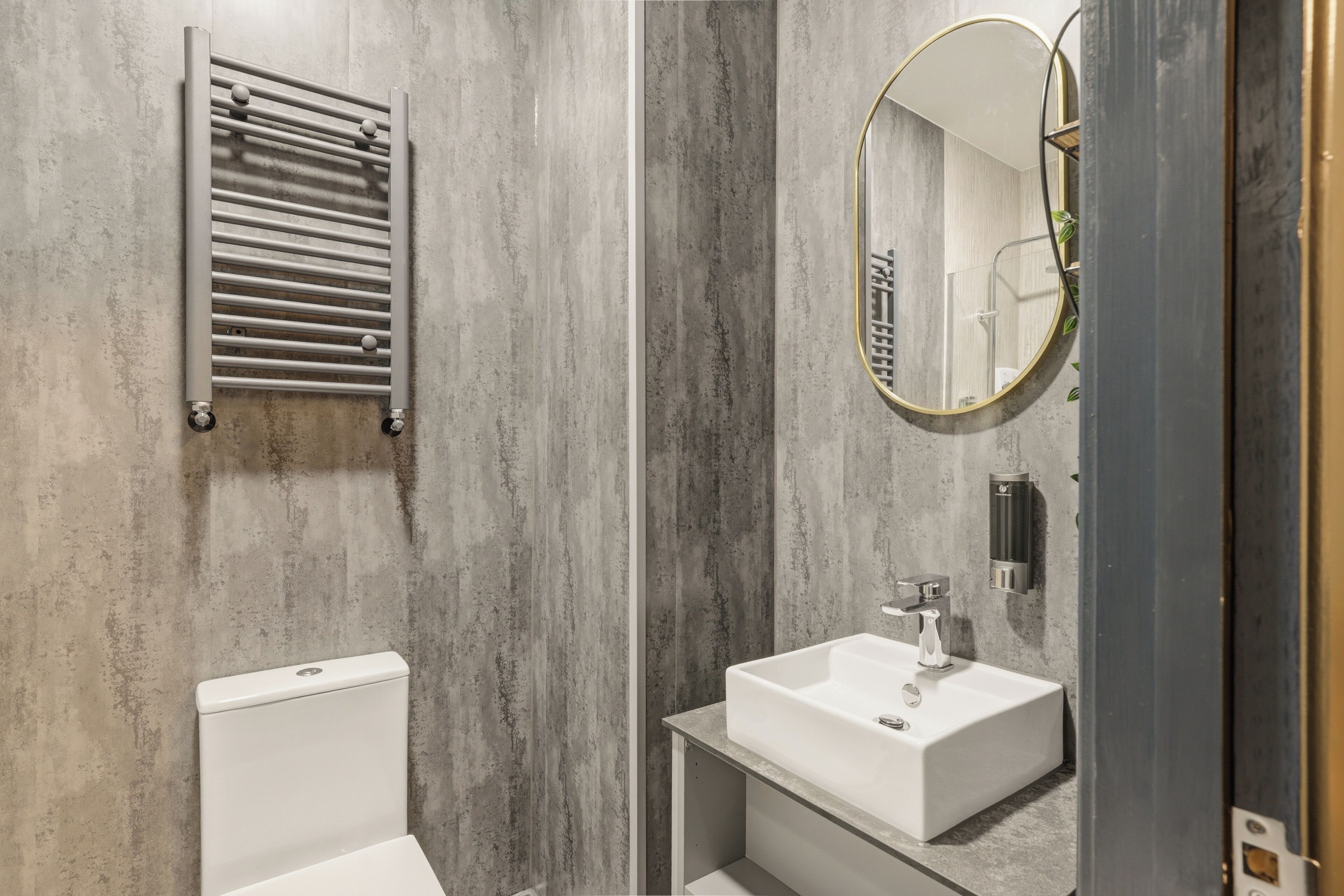 A modern bathroom with a toilet, a sink, a towel rack, and a mirror.