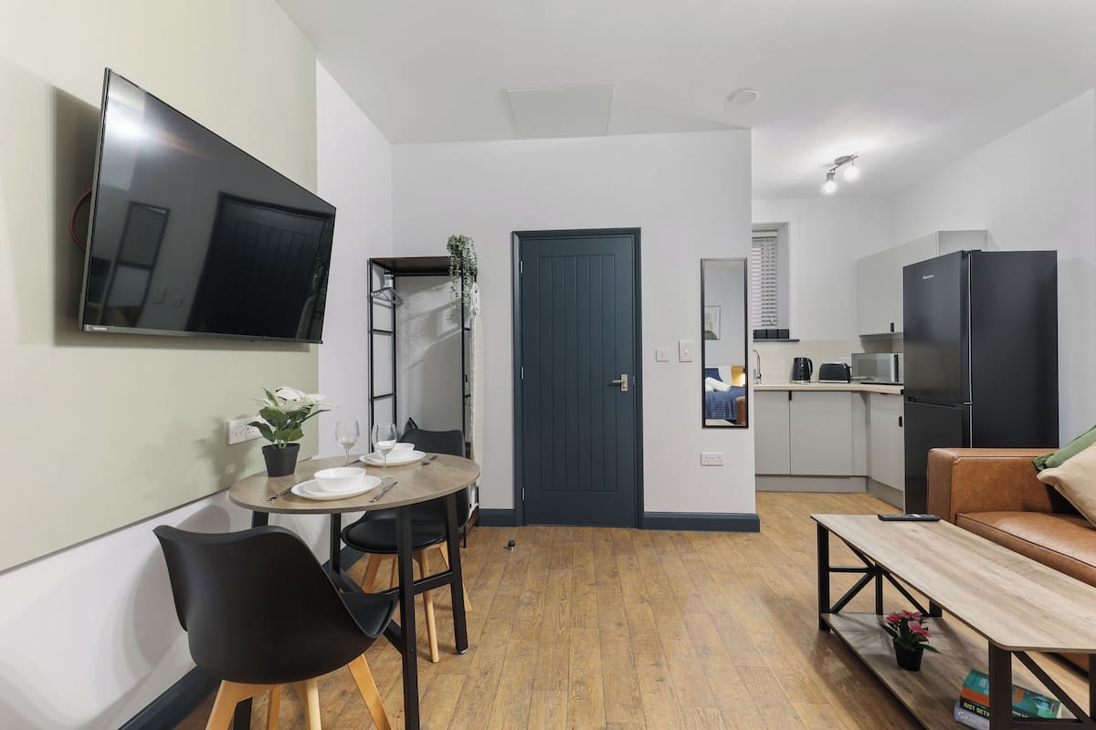 Un espacio habitable compacto con comedor, kitchenette y zona de estar.