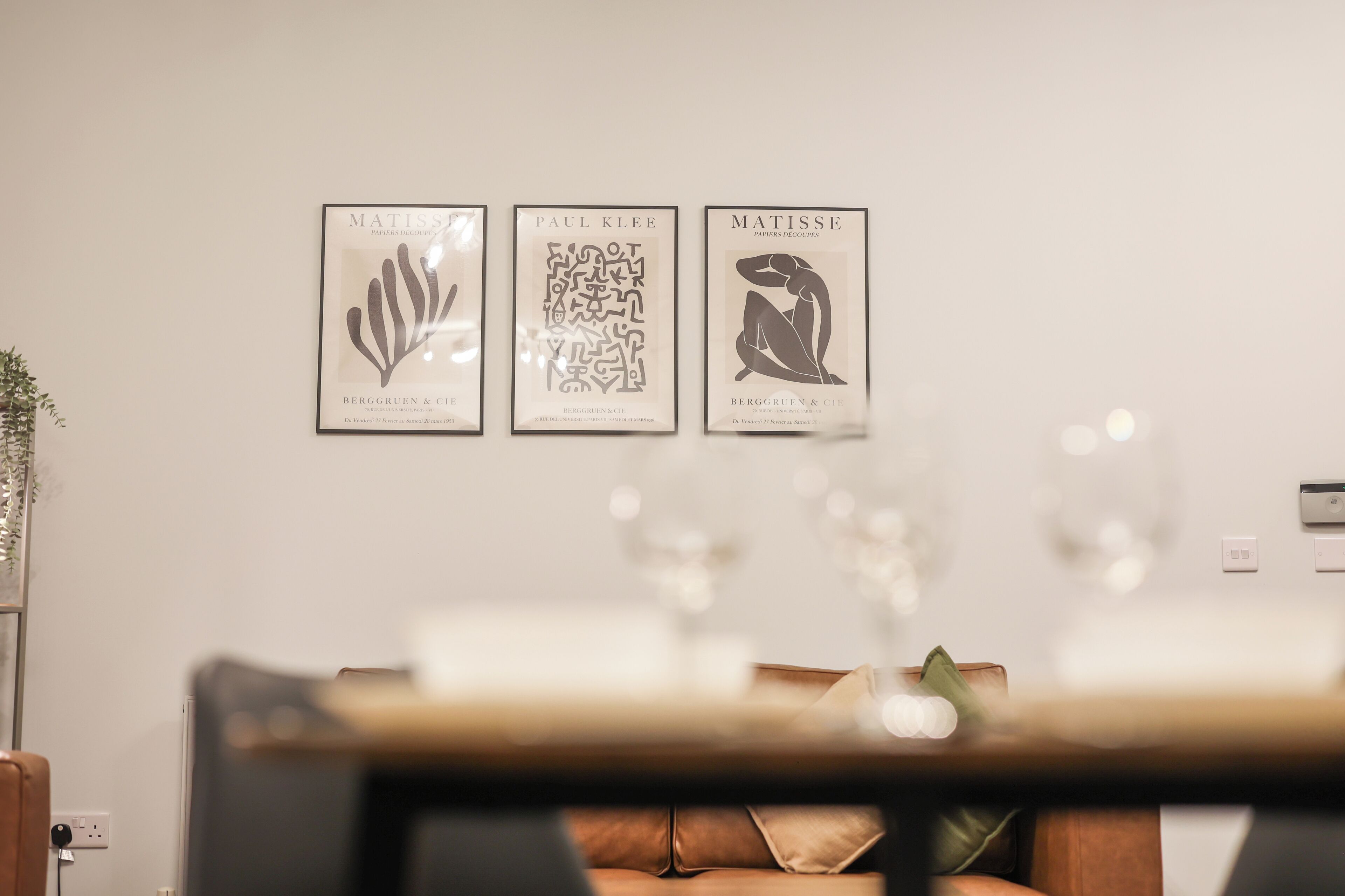 Three framed artworks on a wall in a living room.
