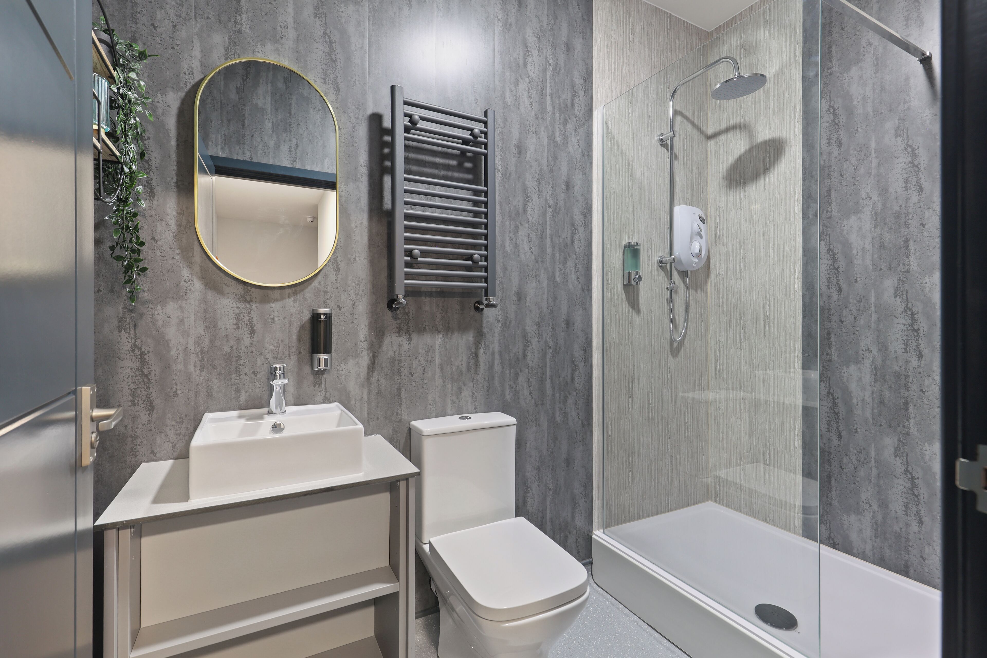 A modern bathroom with a white sink, toilet, and shower.