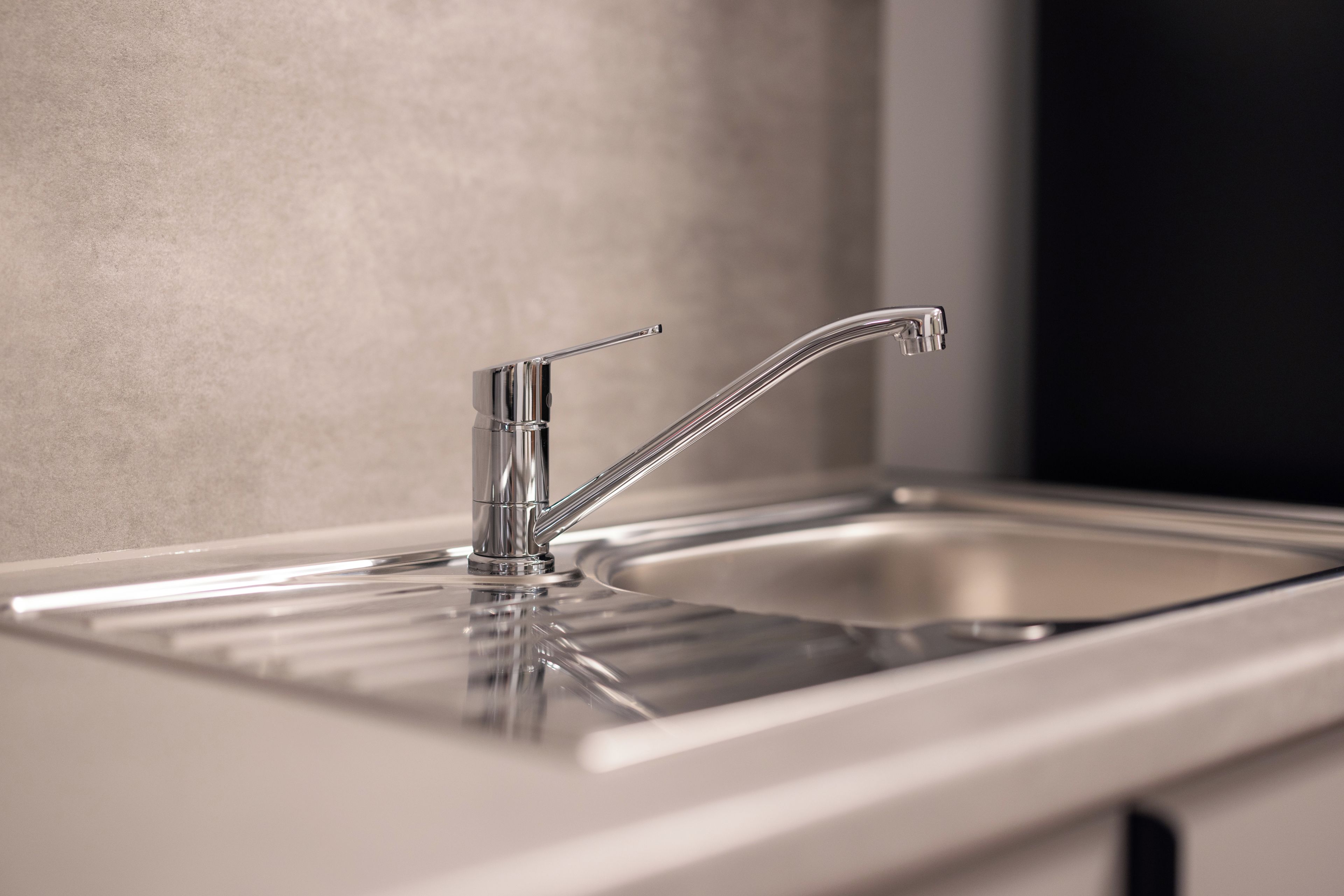 Un moderno lavamanos de cocina con grifo cromado y un lavabo rectangular.