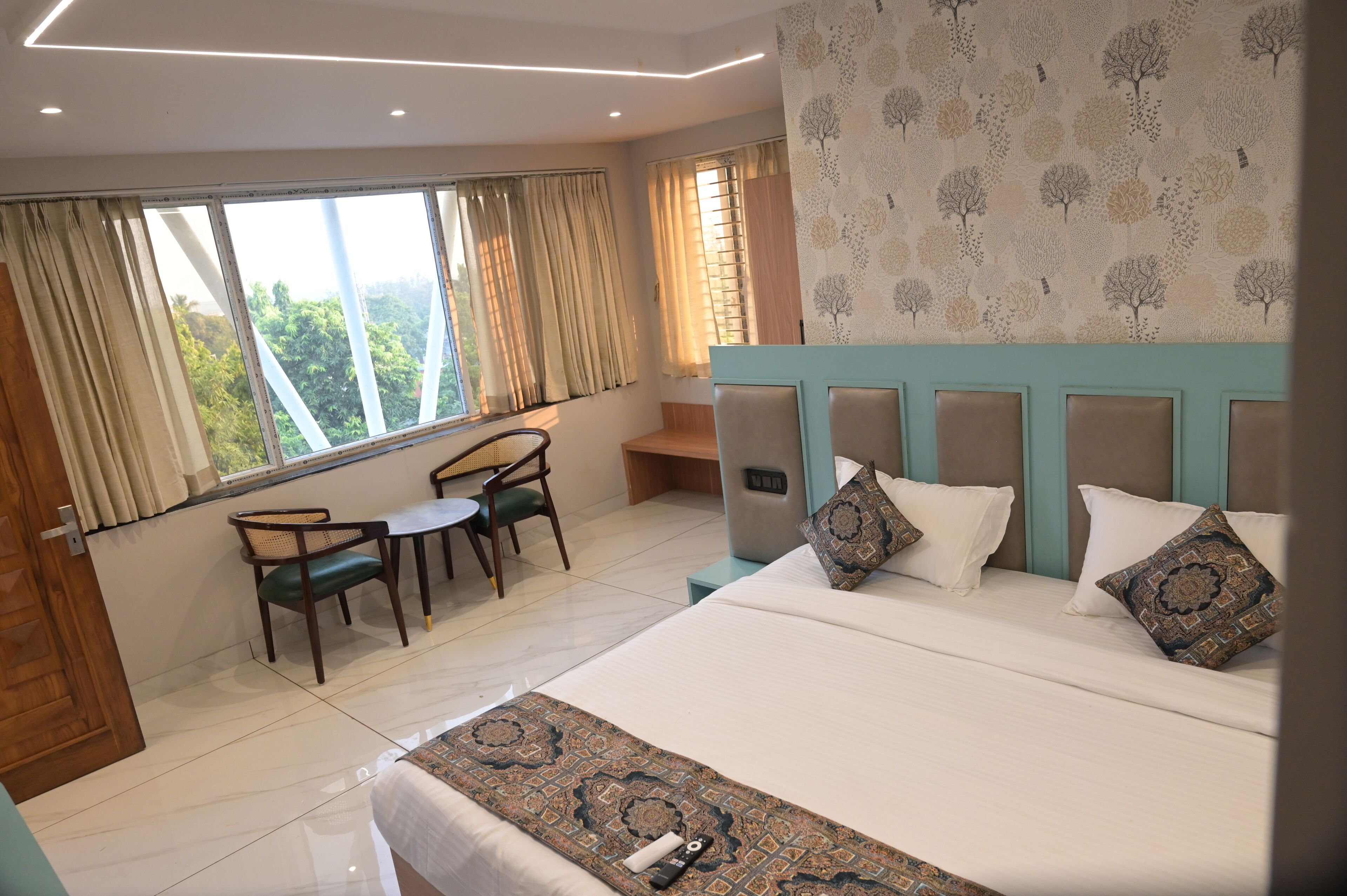 A hotel room with a bed, a desk, and a chair.