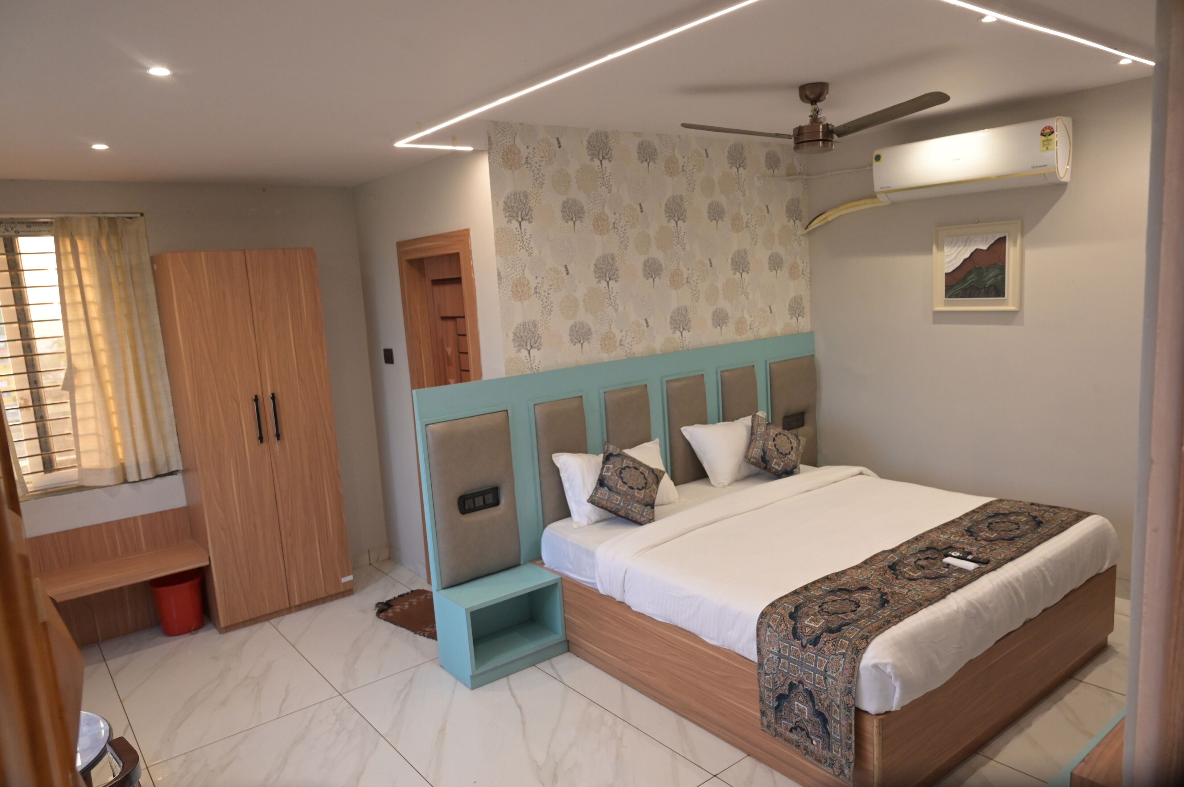 A bedroom with a bed, a wardrobe, a ceiling fan, and an air conditioning unit.