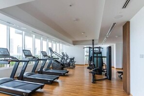 Ein Fitnessstudio mit Laufbändern, Crosstrainern und Krafttrainingsgeräten.