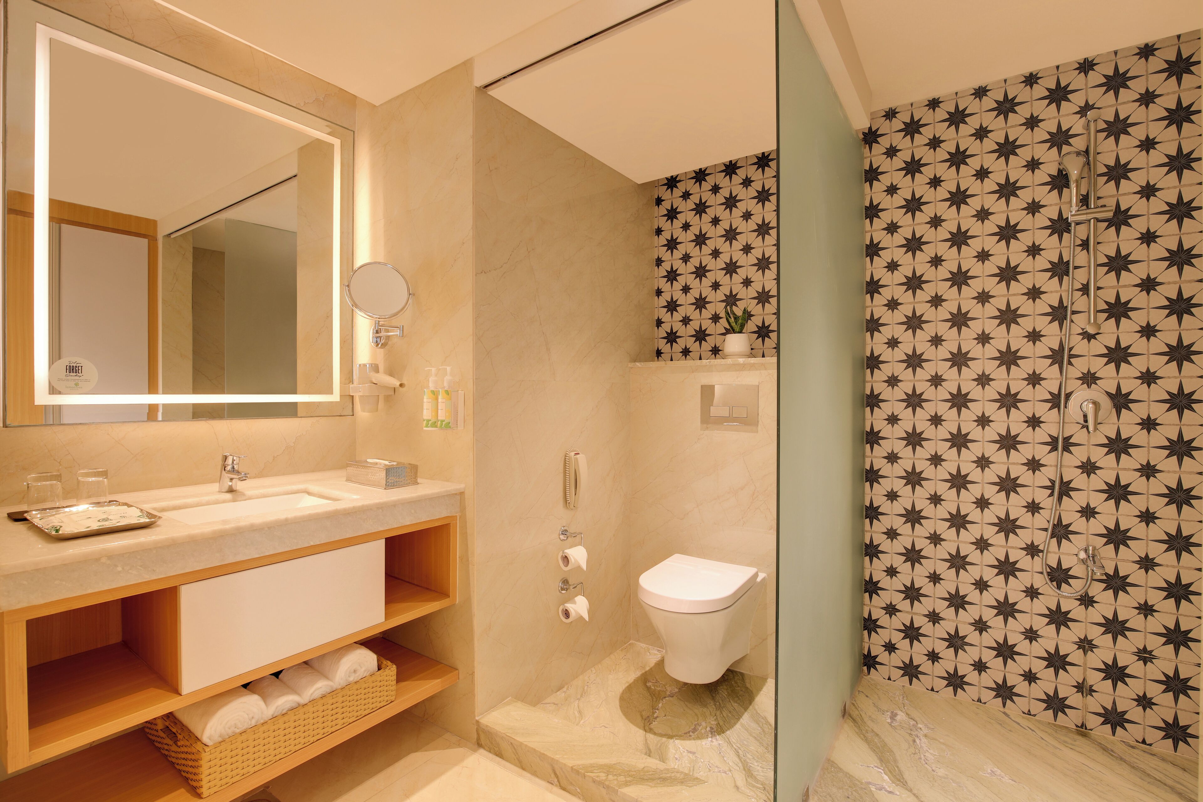A modern bathroom with a large mirror, a sink, a toilet, and a shower area.
