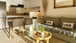 Una sala de estar moderna con un sofá, dos sillones, una mesa de centro y una mesita con una planta.