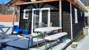 Eine Holzhütte mit Veranda, einem Tisch und Bänken.