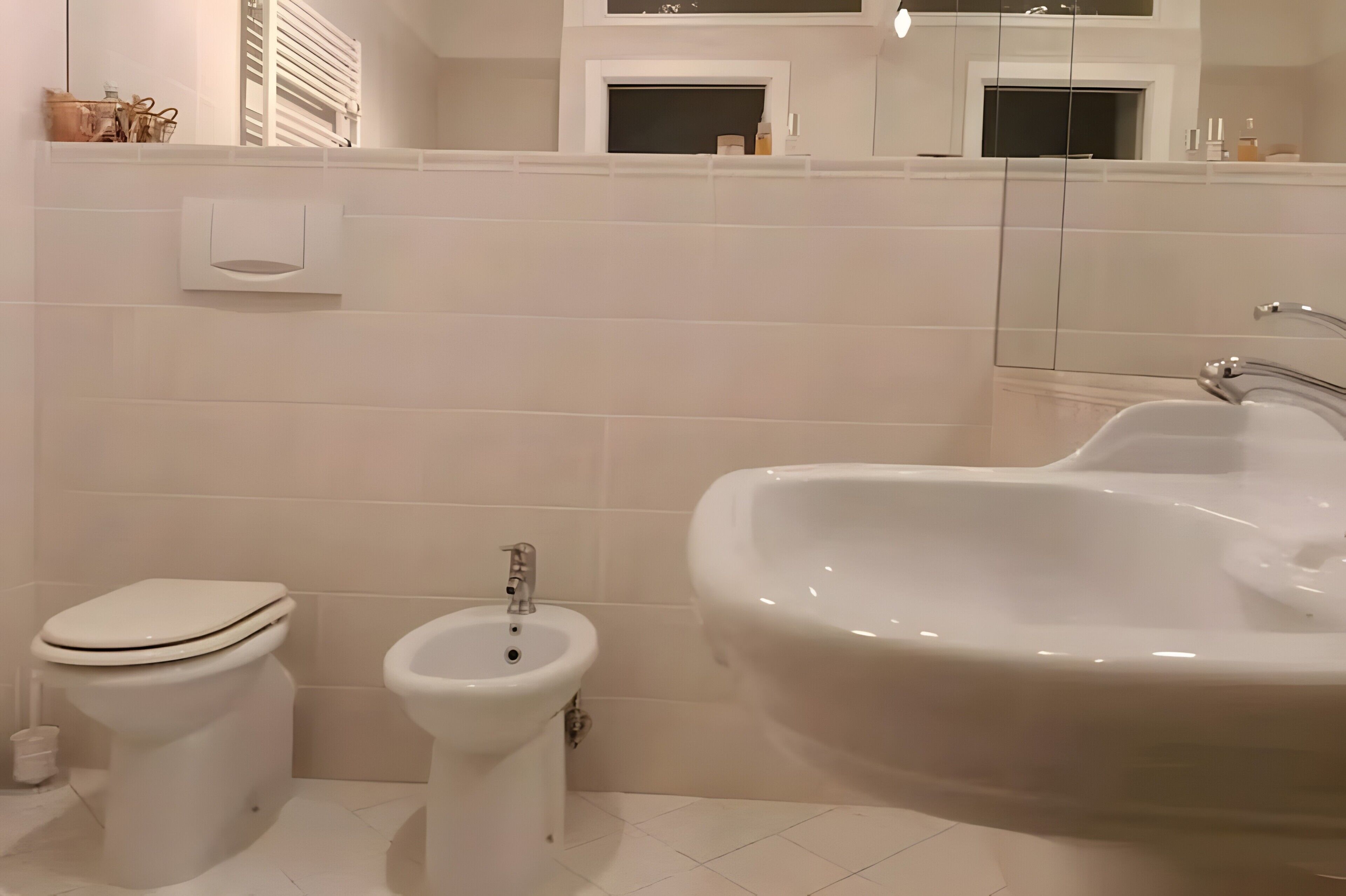 A bathroom with a toilet, bidet, and sink.
