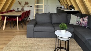 An attic room with a loft bed, a dining table with chairs, a sofa, and a small table with a plant. - Parc Sonnleiten - Edelhert (Gnesau)