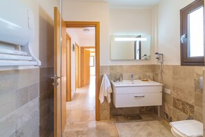 Ein Badezimmer mit Dusche, Waschbecken und Toilette.