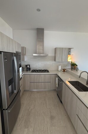 A modern kitchen with a stainless steel refrigerator, gas stove, and a built-in oven. - Oceanfront Sunset Paradis. Famous surfing spot! (LosCerritos)