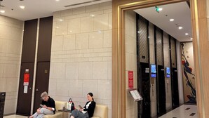A lobby with two sofas, a reception desk, and an elevator area. - Rivergate-High Floor-Ben Thanh -Bui Vien (Ho Chi Minh City)