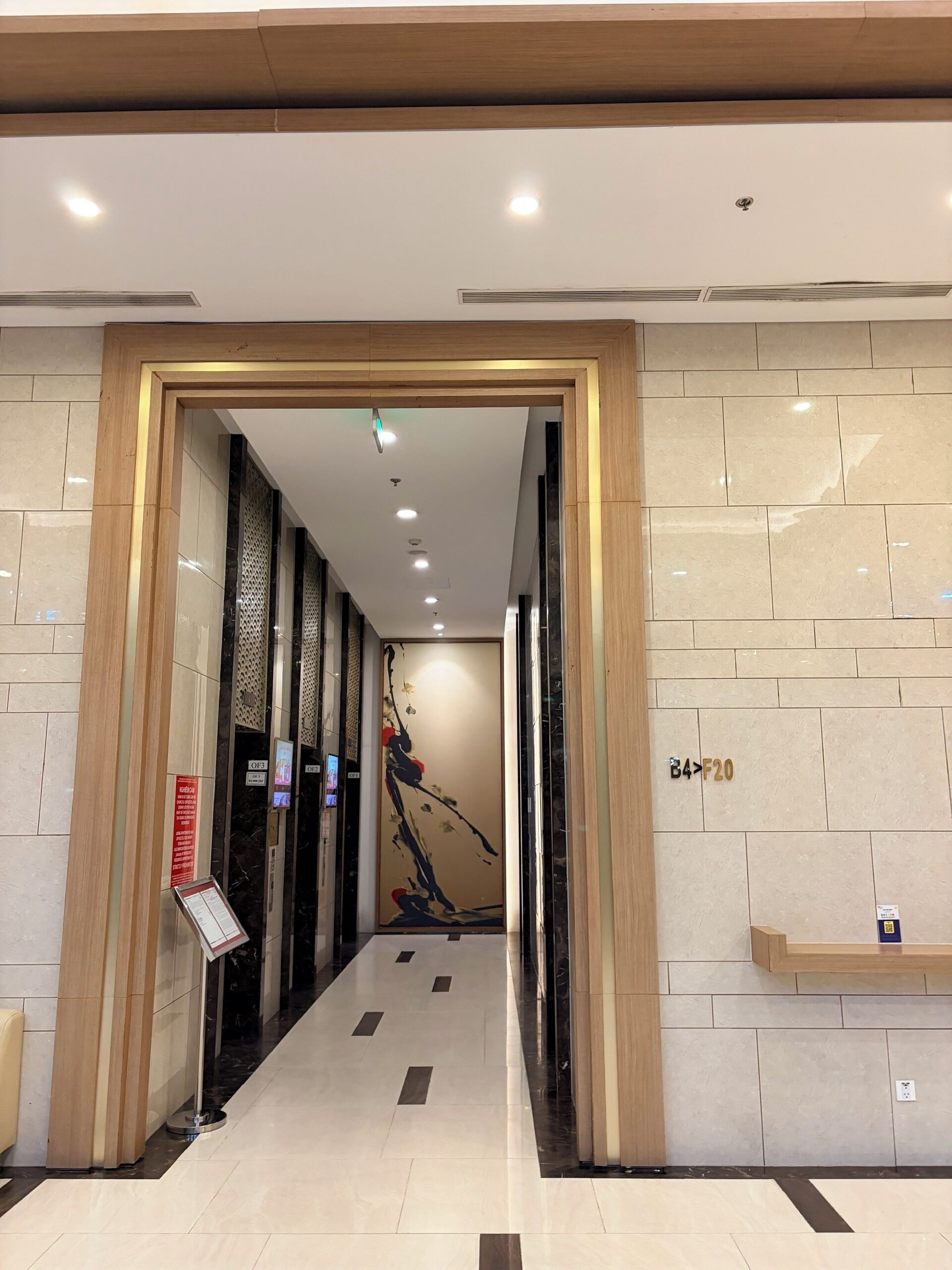 A modern hotel lobby with a clean, tiled floor and a wooden-framed entrance.