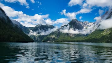 A serene lake surrounded by mountains with a clear sky.