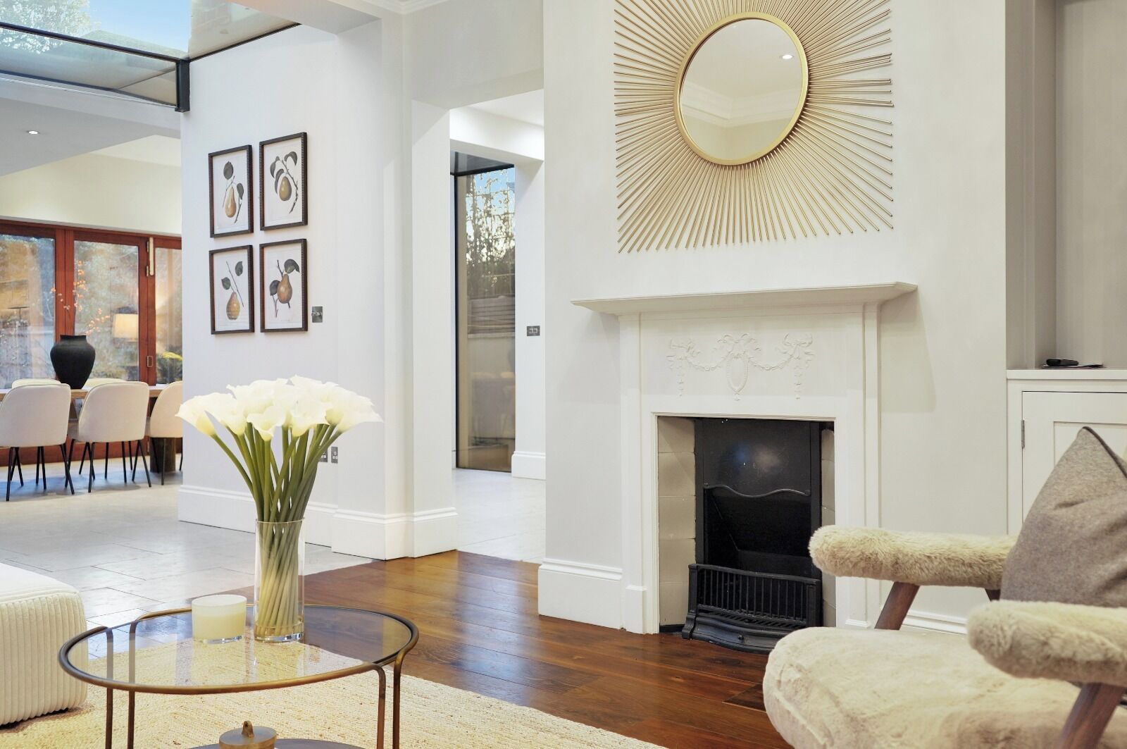 A modern living room with a fireplace, a glass coffee table, and a comfortable armchair.