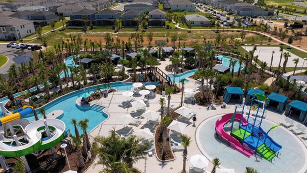 Un resort con un'ampia area piscina, scivoli d'acqua e lettini.