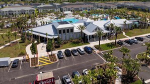 Un hotel con piscina, parcheggio e palme.
