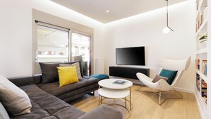 En moderne stue med sofa, lænestol og sofabord.