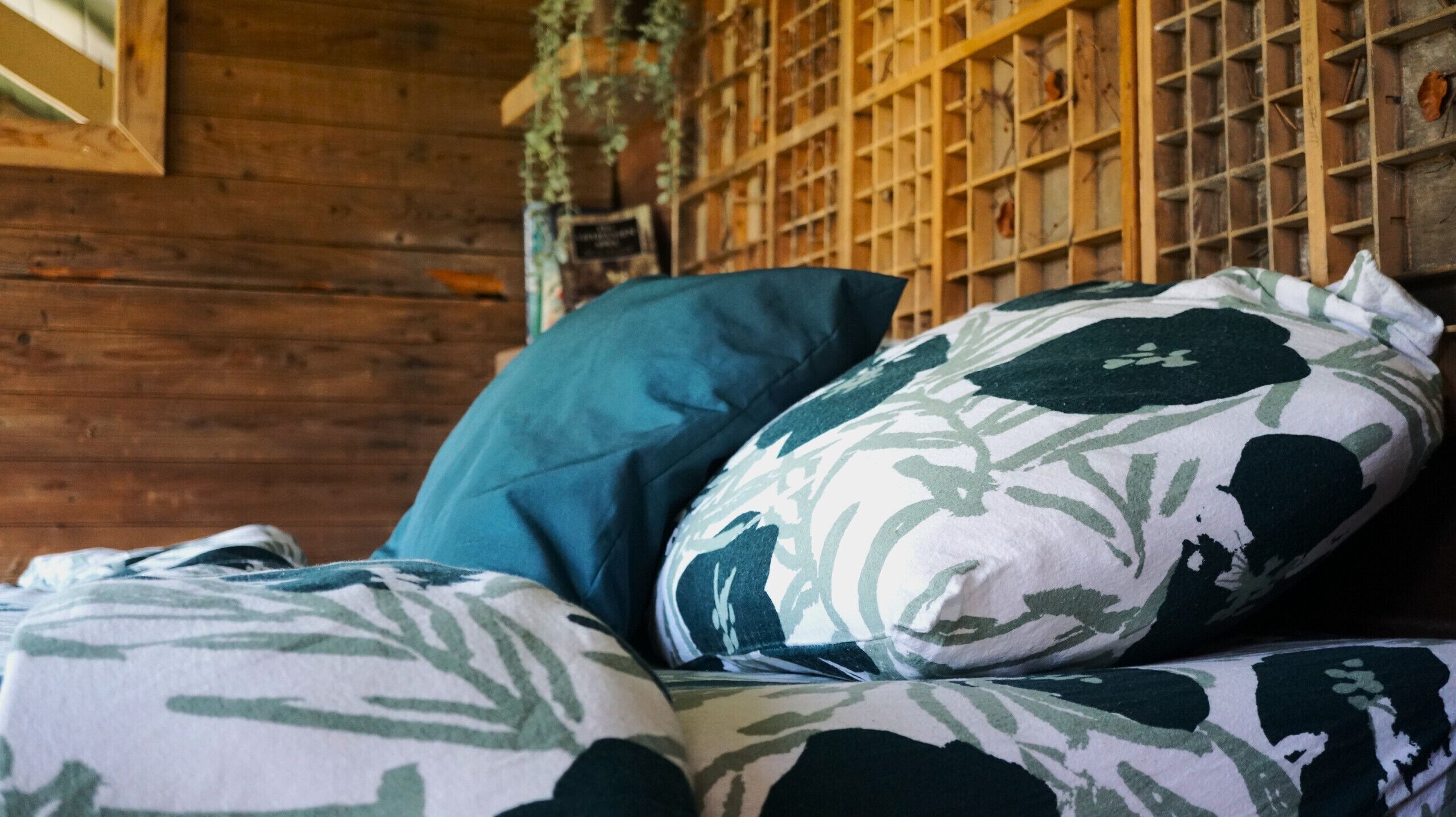 A bed with patterned pillows and a wooden headboard.