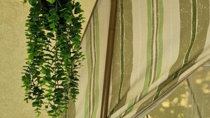 Una carpa con interior de tela a rayas, una planta colgante y una ventana de mosquitera.