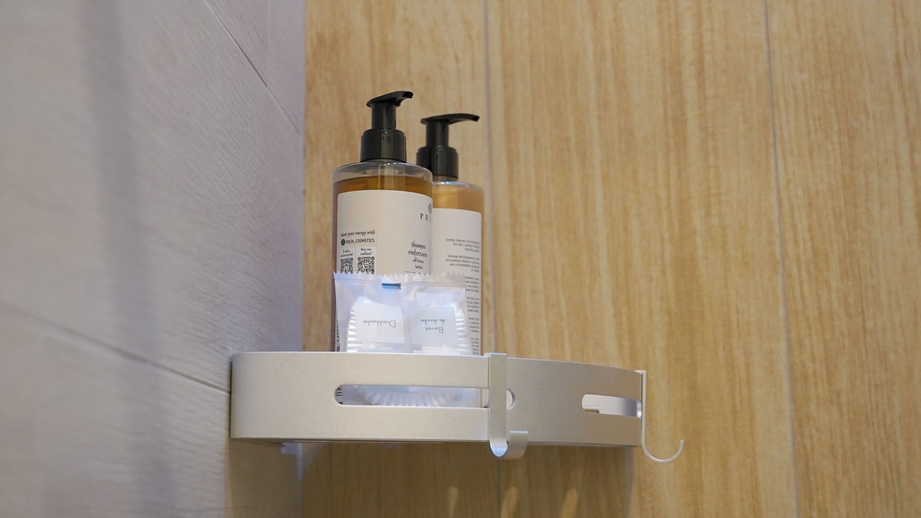 A bathroom shelf with two bottles of shampoo and conditioner.