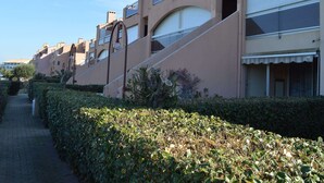 A row of modern buildings with balconies, a paved walkway, and neatly trimmed hedges. - 2-room Apartment - 6 people, Parking near beach (Saint-Cyprien)