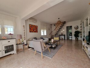 A spacious living area with a sofa, coffee table, and a staircase leading to another level. - House in L'Escala with private pool and air conditioning, near beach (L'Escala)