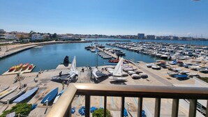 A marina with boats docked, a clear sky, and buildings in the background. - Studio with Terrace Near Beach in L'Escala (L'Escala)