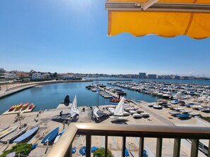 A marina with boats docked, a clear sky, and buildings in the background. - Studio with Terrace Near Beach in L'Escala (L'Escala)