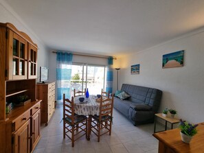 Ein Essbereich mit Tisch und Stühlen, einer Couch und einem kleinen Tisch mit Pflanzen.