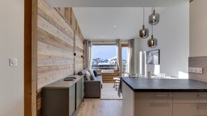 A modern kitchen with a wooden accent wall, a built-in bench, and pendant lighting. - 45m² Duplex for 4, ski-in ski-out in Tignes Val Claret (Tignes)