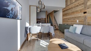 A modern living space with a dining area, a sofa, and a staircase. - 45m² Duplex for 4, ski-in ski-out in Tignes Val Claret (Tignes)