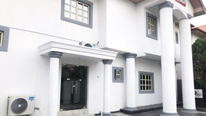 A building with a white facade, large columns, and a glass entrance. - Davalon suites & Apartments (Lekki)