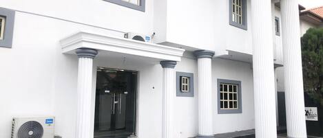 A building with a white facade, large columns, and a glass entrance.