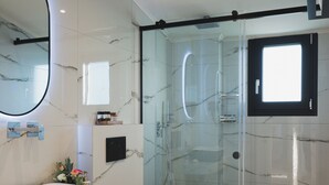 A modern bathroom with a glass-enclosed shower, a marble sink, and a large mirror. - The Olive Nest by Elite (Zakynthos)