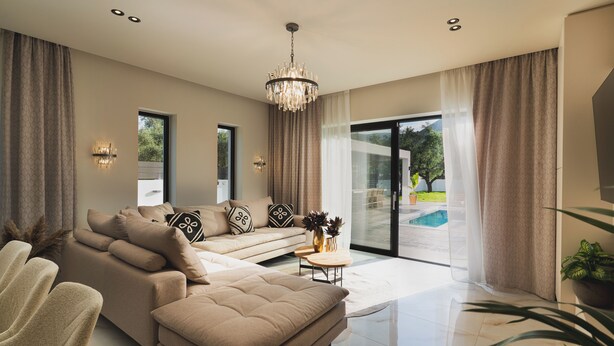 A modern living room with a sofa, a coffee table, and a chandelier. - The Olive Nest by Elite (Zakynthos)