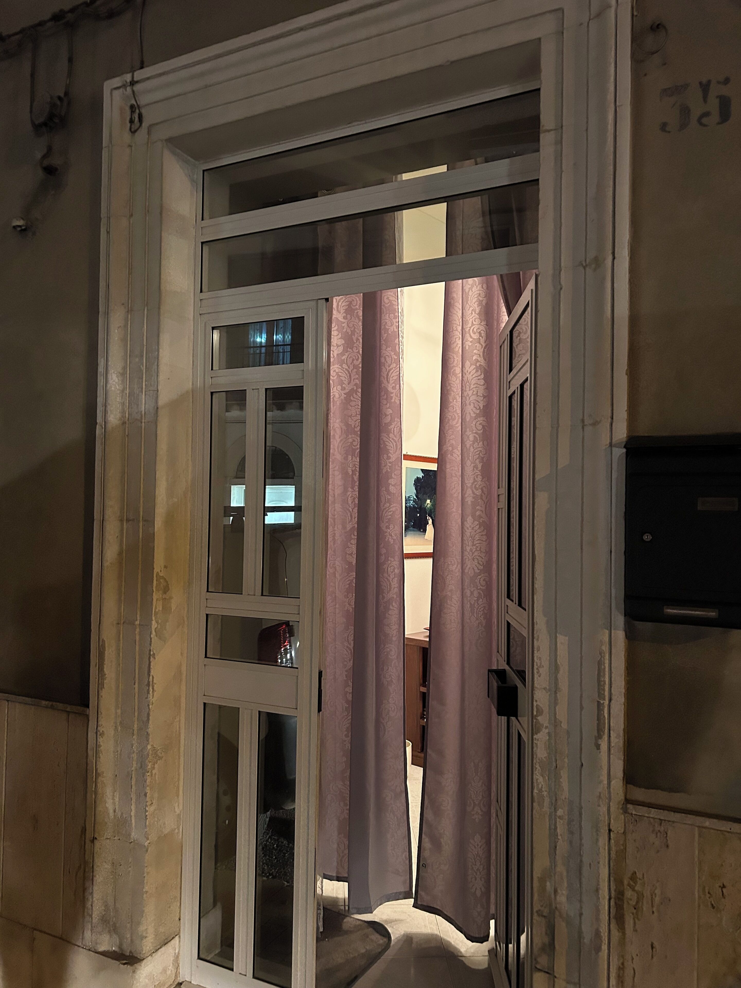 Una porta con un pannello di vetro e una tenda.