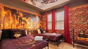Ein Zimmer mit zwei Betten, einer Backsteinwand und einem Wandgemälde eines Schlosses.