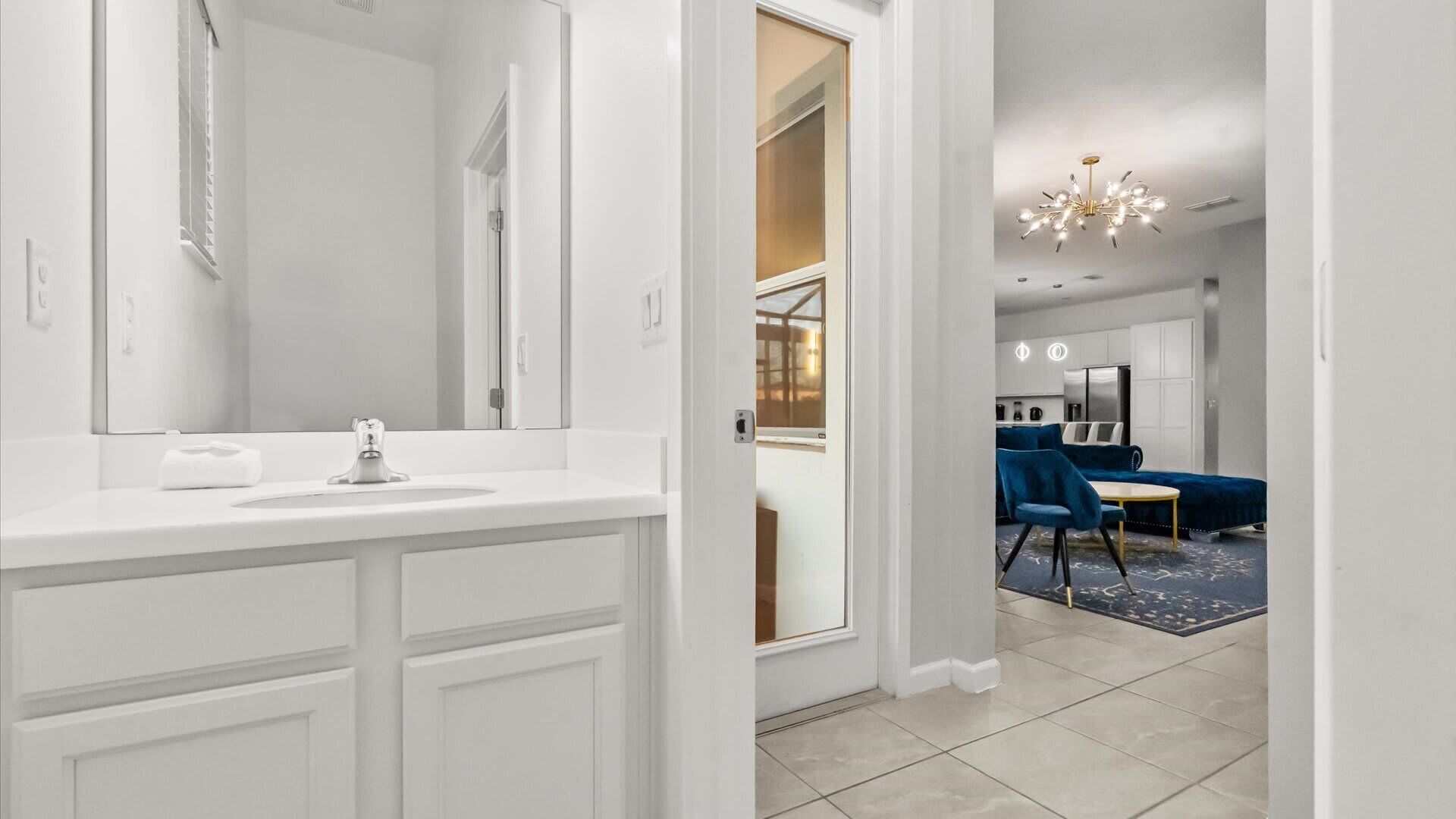 A modern bathroom with a white vanity, a large mirror, and a shower area.