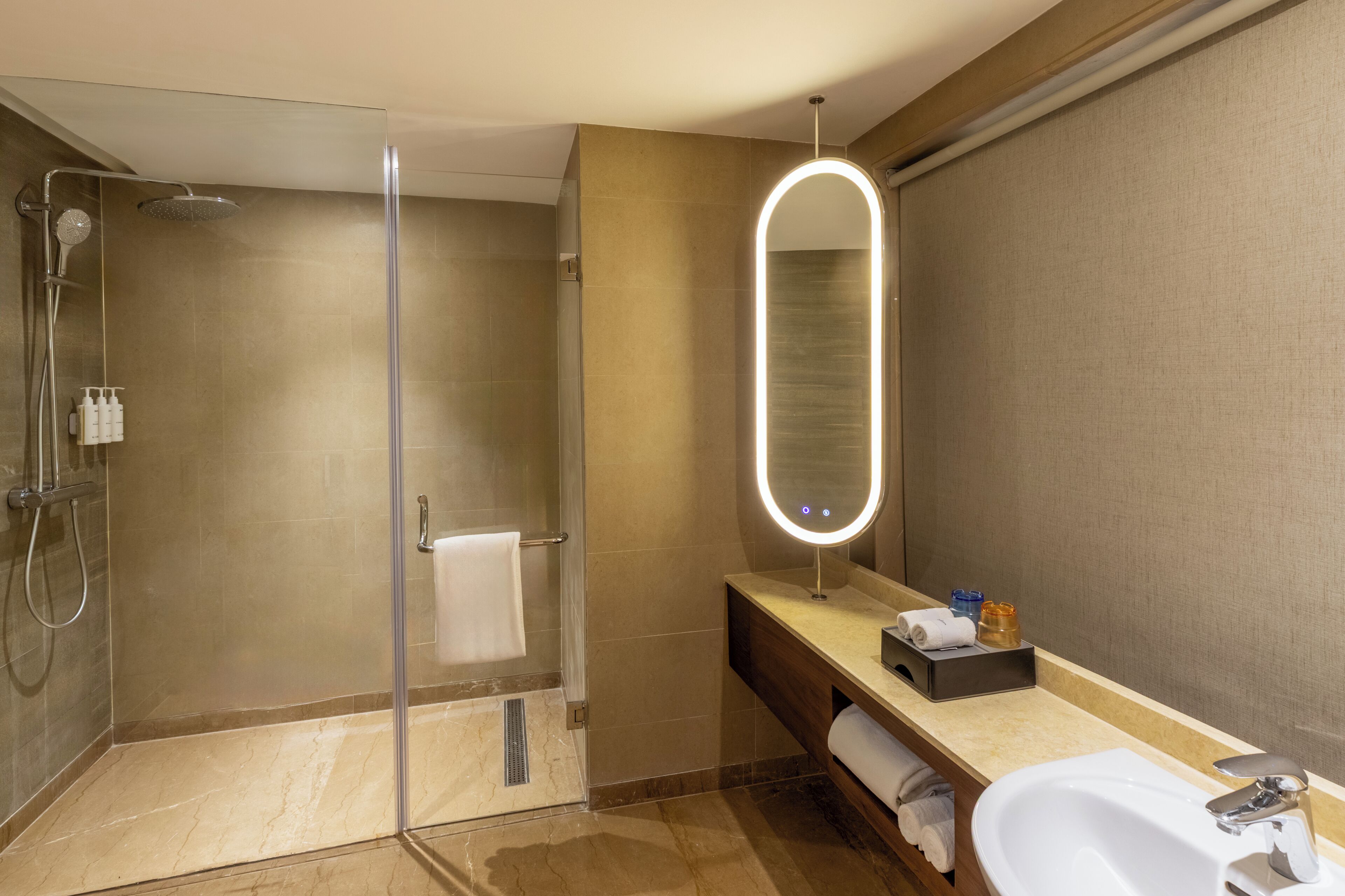 A modern bathroom with a glass-enclosed shower, a vanity with a mirror, and a sink.
