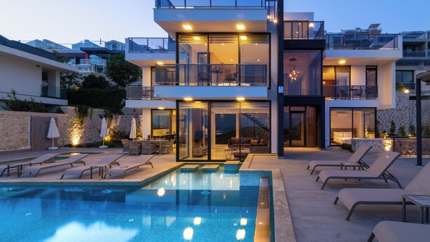 A modern multi-story building with a rooftop terrace, a swimming pool, and sun loungers. - Eco Villa Mirada (Kalkan)