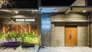 A building with a sign reading "SNUG" and a wooden door.