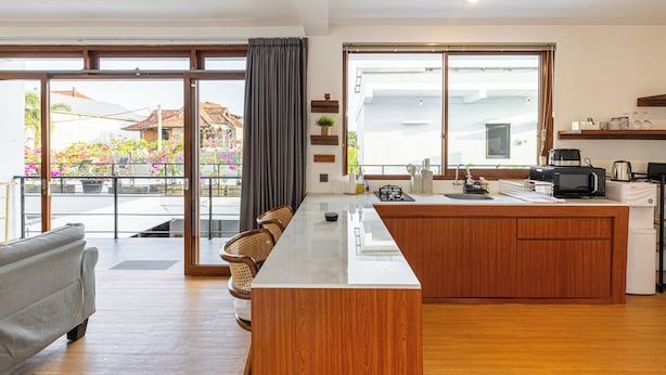 Cozinha moderna com ilha central, grandes janelas e vista para o exterior.