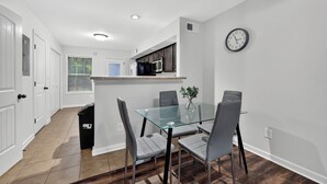 Una cocina moderna con armarios oscuros, un microondas y un reloj en la pared.