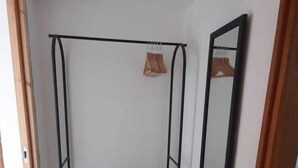 A room with a metal bed frame, a brown carpet, a mirror, and a door. - 1-bedroom, AC, Wifi, 10 minutes from Rashbi, 3 minutes from Safed Old City (Safed)